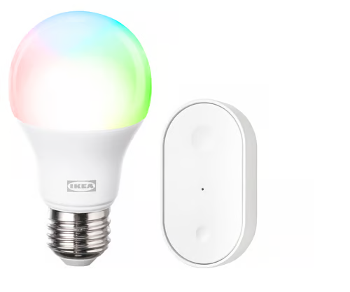 An Ikea smart bulb glowing in rainbow colors, next to a small white oval Ikea wireless remote.